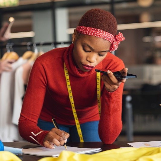 A photo of a talented fashion designer calling her suppliers