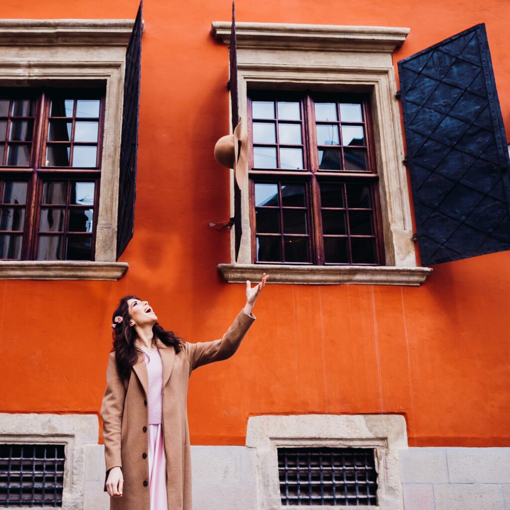 A woman celebrating outside an orange property