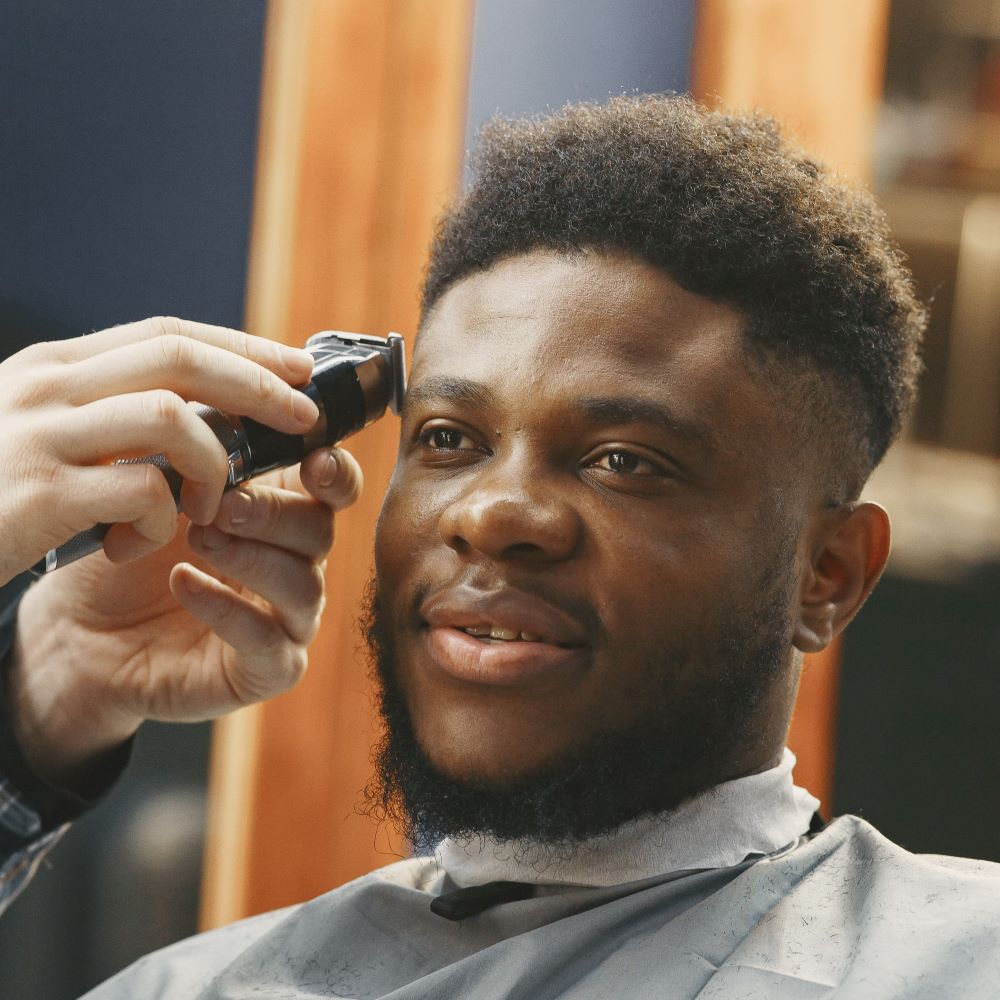 A young Black man getting a fade at a barbershop